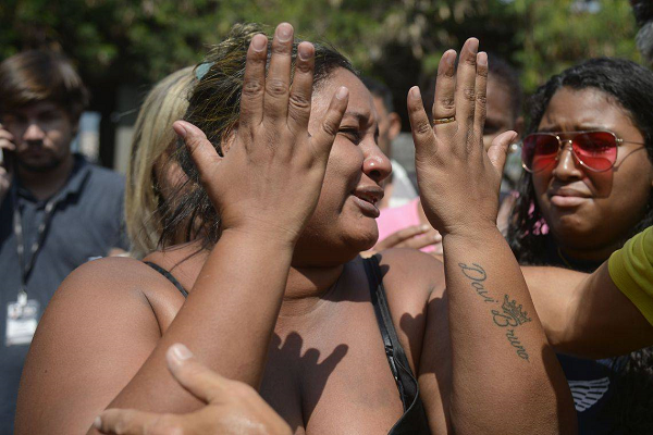 Luciana chegou ao IML amparada por parentes e amigos. Ela contou que ainda não teve coragem de contar ao filho que o pai morreu (Foto: Reprodução)