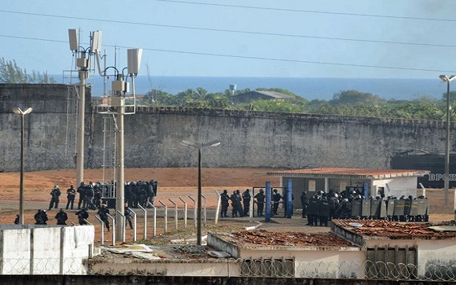 No portão do presídio permanecem homens da Força Nacional, bombeiros e ambulâncias (Foto: Reprodução)